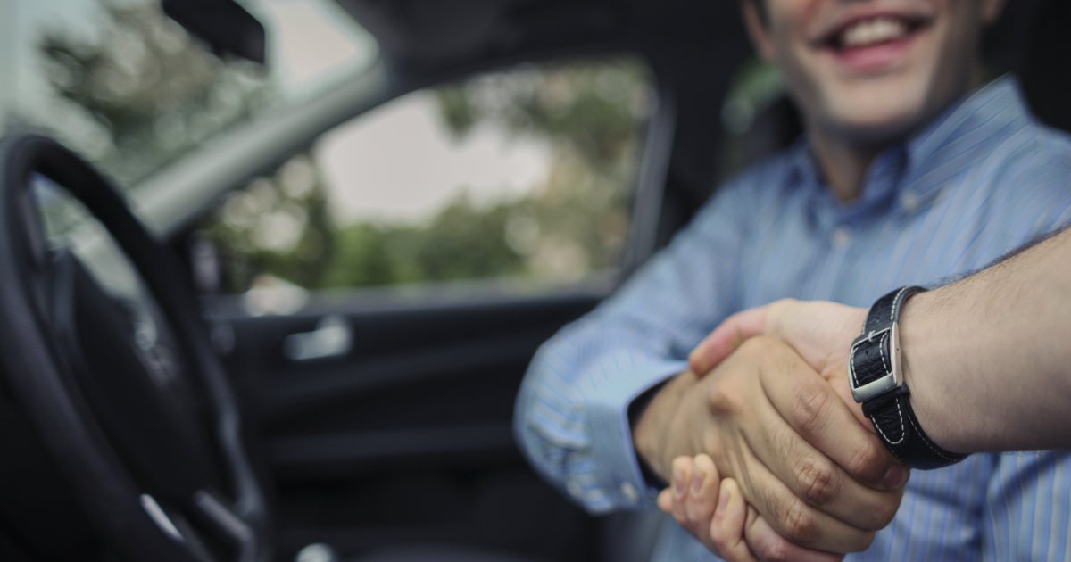 Image of handshake between client and respresentative inside the vehicle