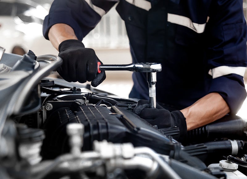 Image of a man working on the car engine